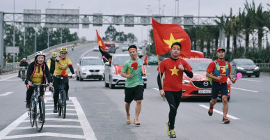 Chùm ảnh: Người hâm mộ cầm cờ Tổ quốc, chạy bộ ra sân bay Nội Bài để đón U23 Việt Nam