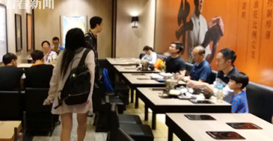 Bà mẹ cho con đi tè vào cốc uống trà ở nhà hàng