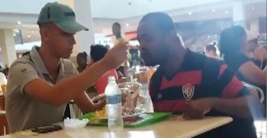 Nhân viên cửa hàng đồ ăn nhanh bón cho khách tàn tật